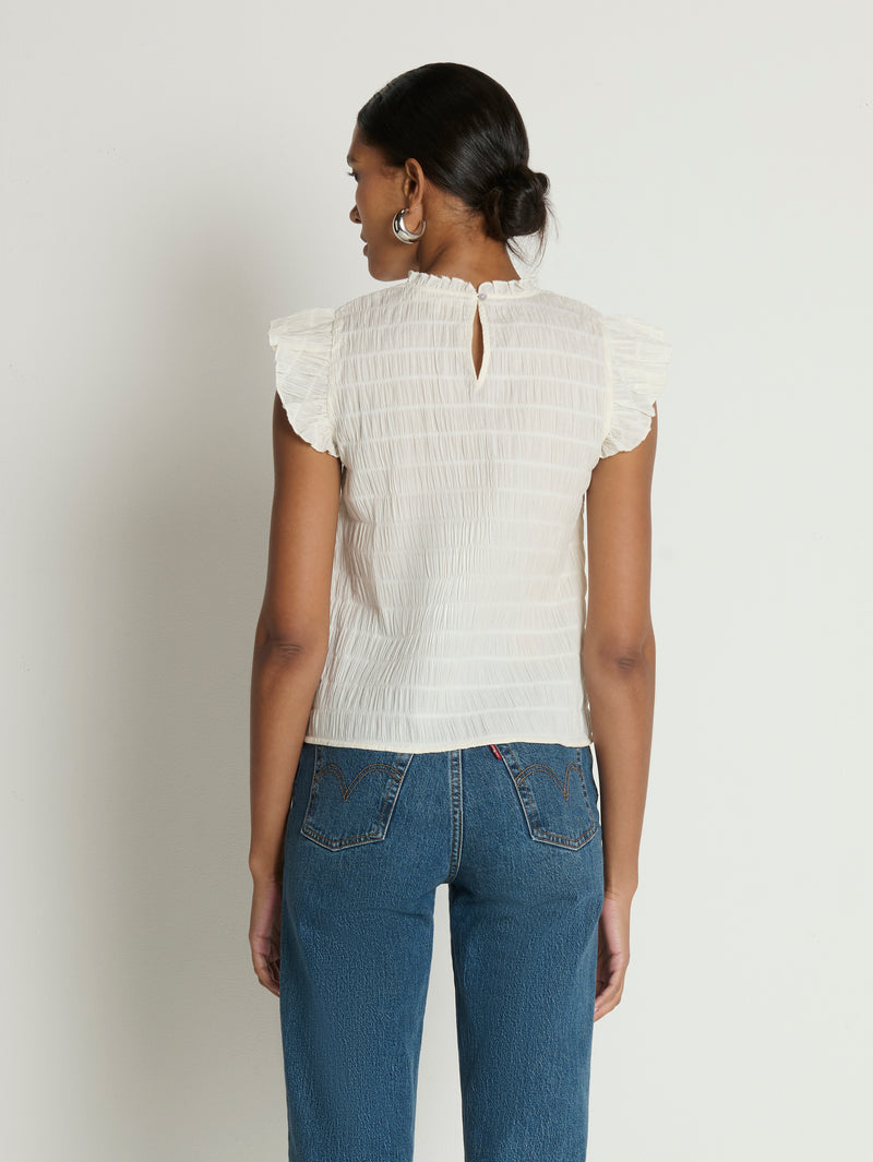 Woman wearing a white ruffle top 