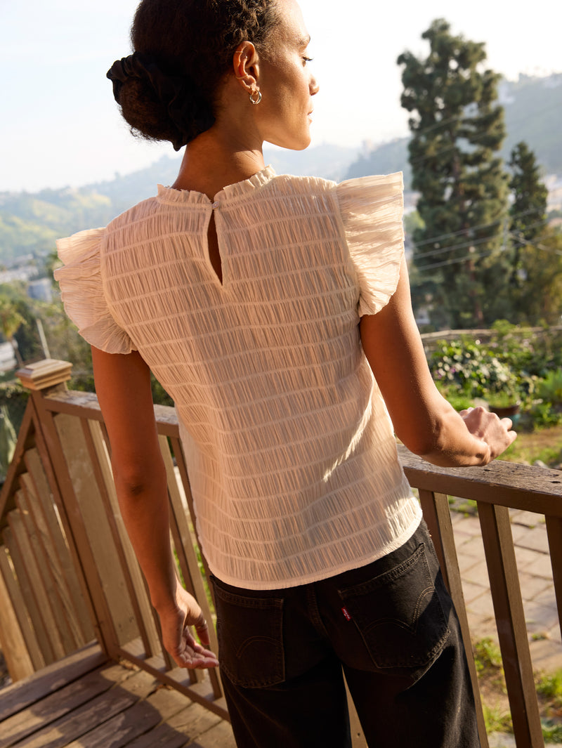 Woman wearing a white ruffle top 
