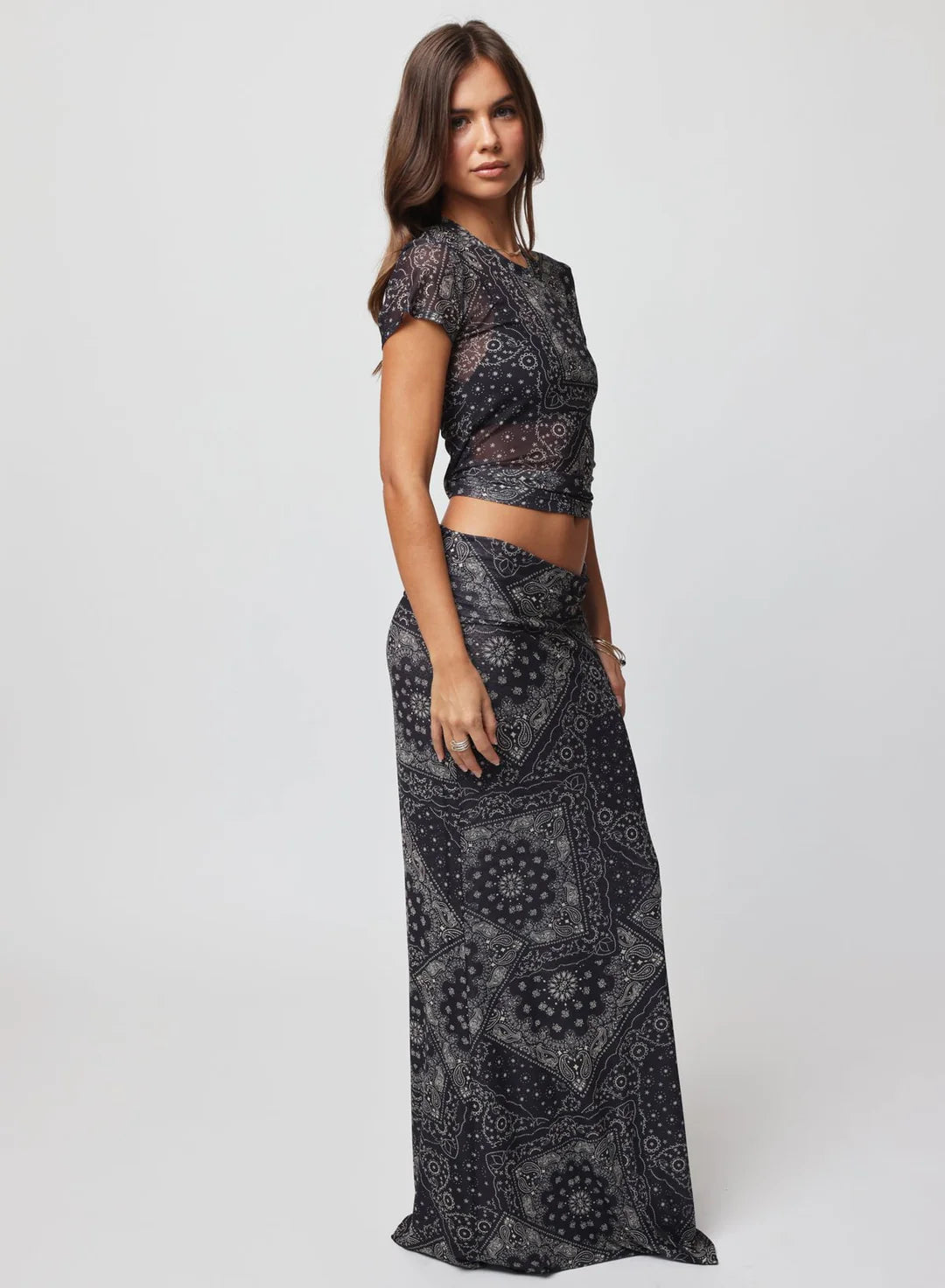 Woman wearing a black patterned outfit on a white background