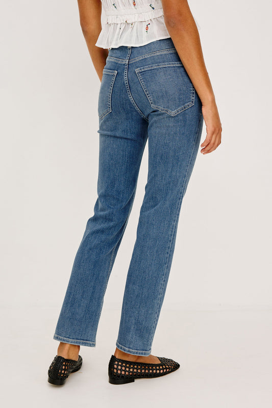 Woman wearing a white floral top and blue jeans 