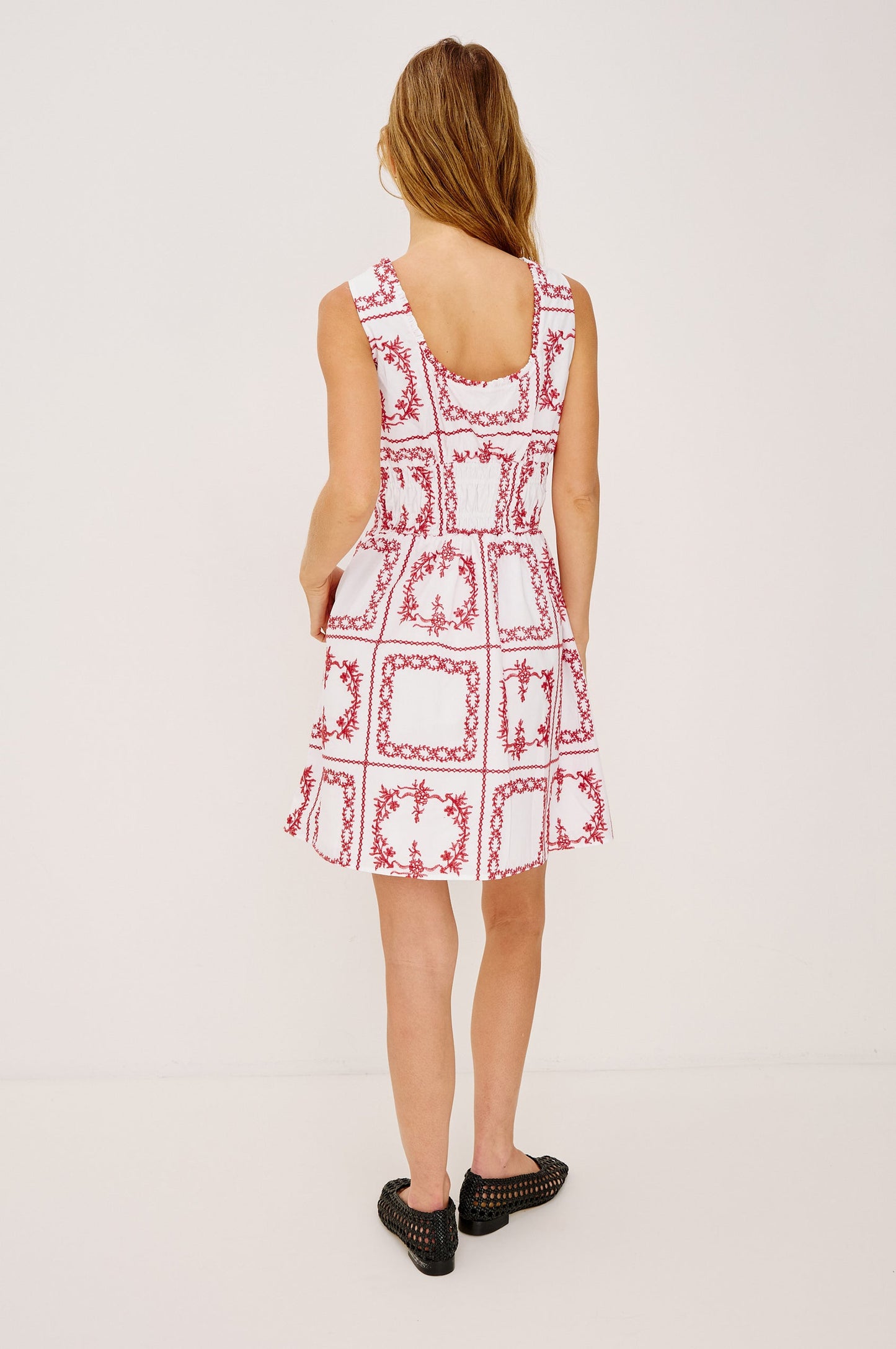 Woman wearing a white dress with red floral patterns 