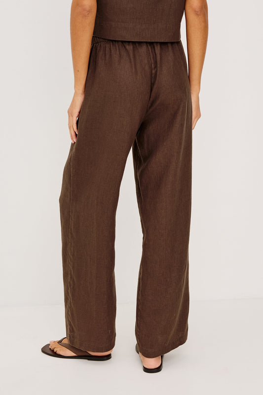Back view of espresso-colored Emmie pants, lightweight material, paired with sandals against a plain background.
