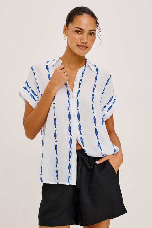 Woman wearing a white shirt with blue sardine patterns