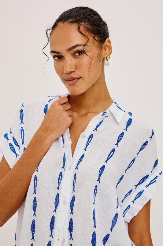 Woman wearing a white shirt with blue sardine patterns