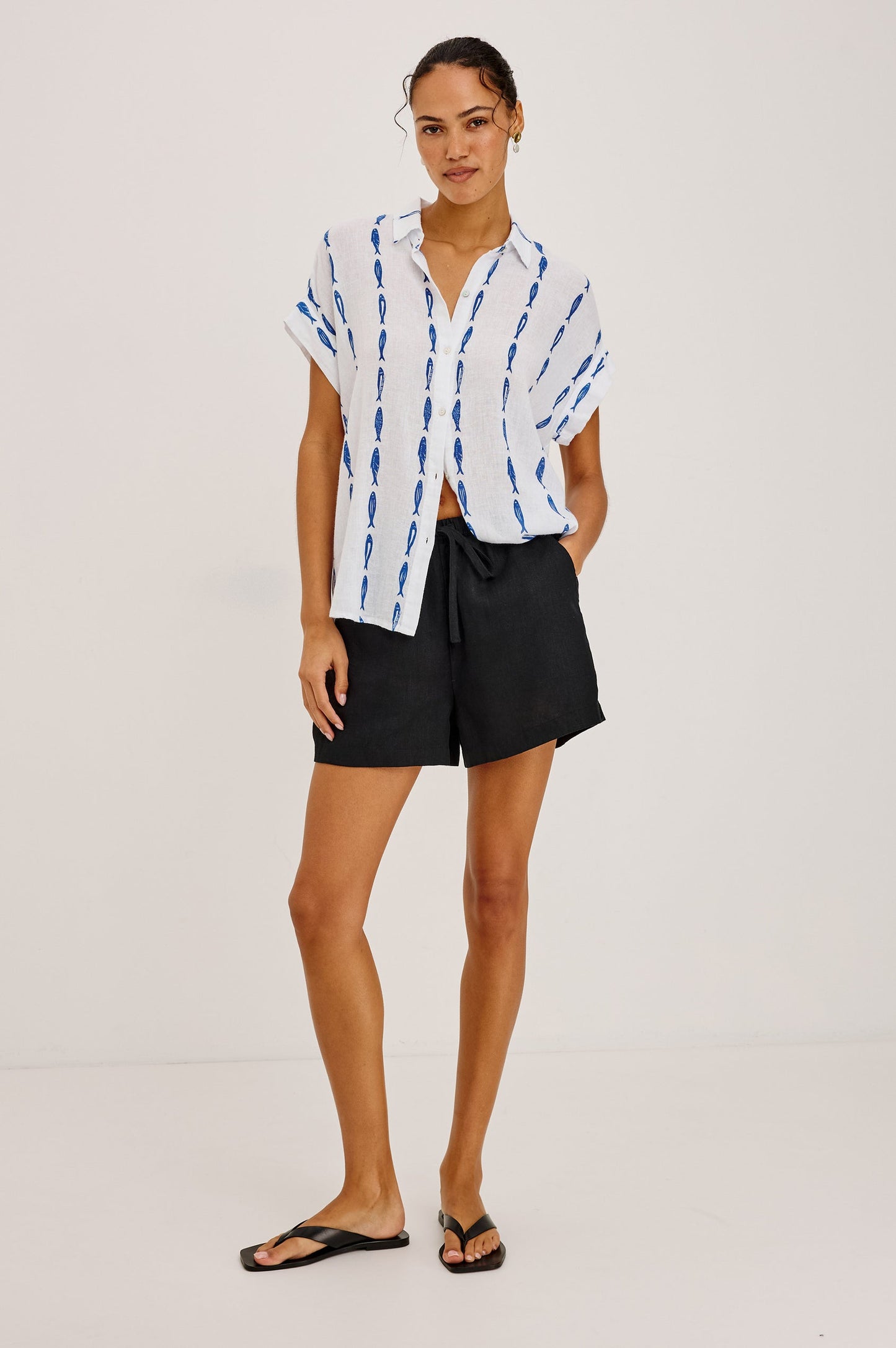 Woman wearing a white shirt with blue sardine patterns 