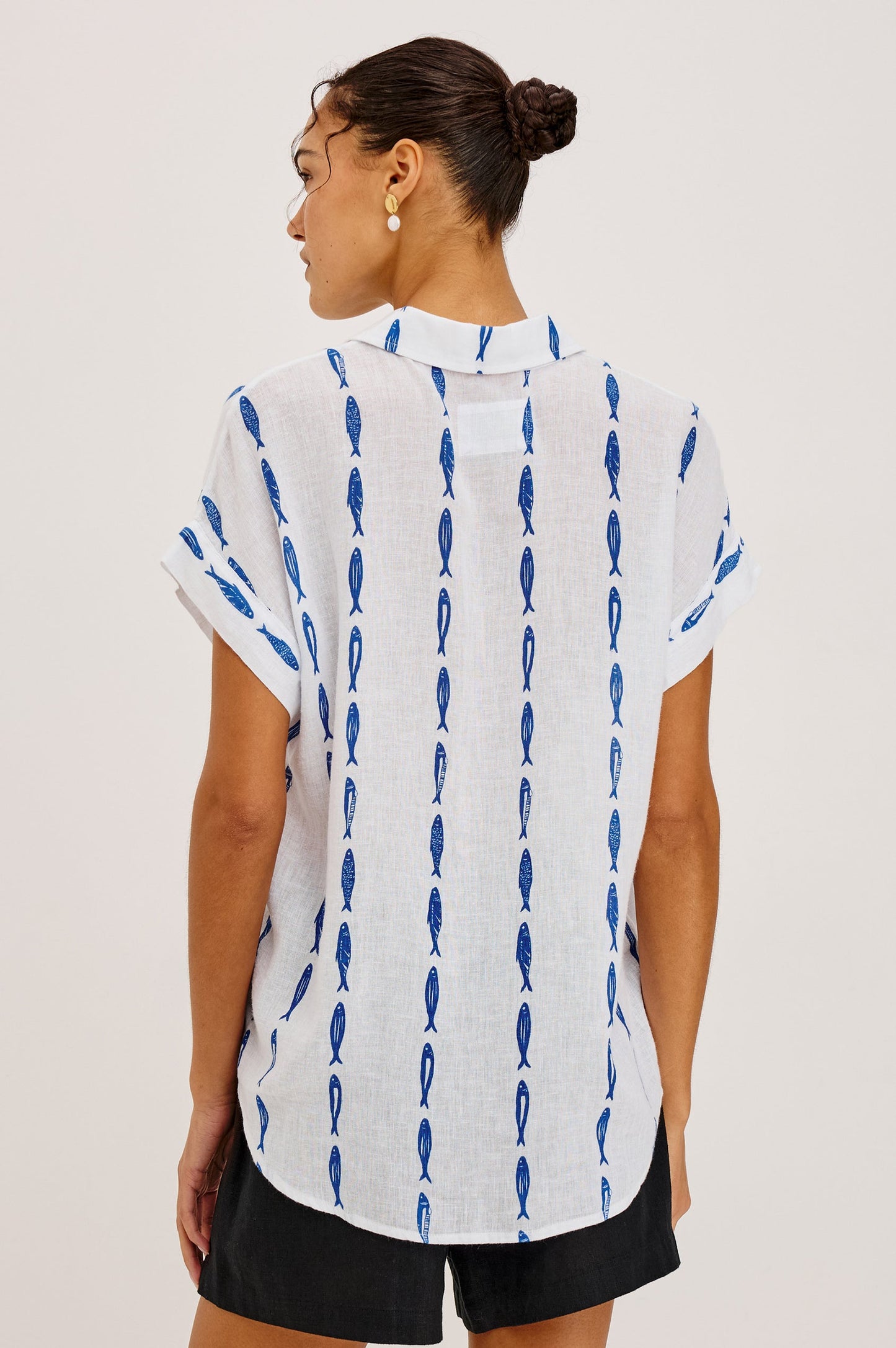Woman wearing a white shirt with blue sardine patterns 