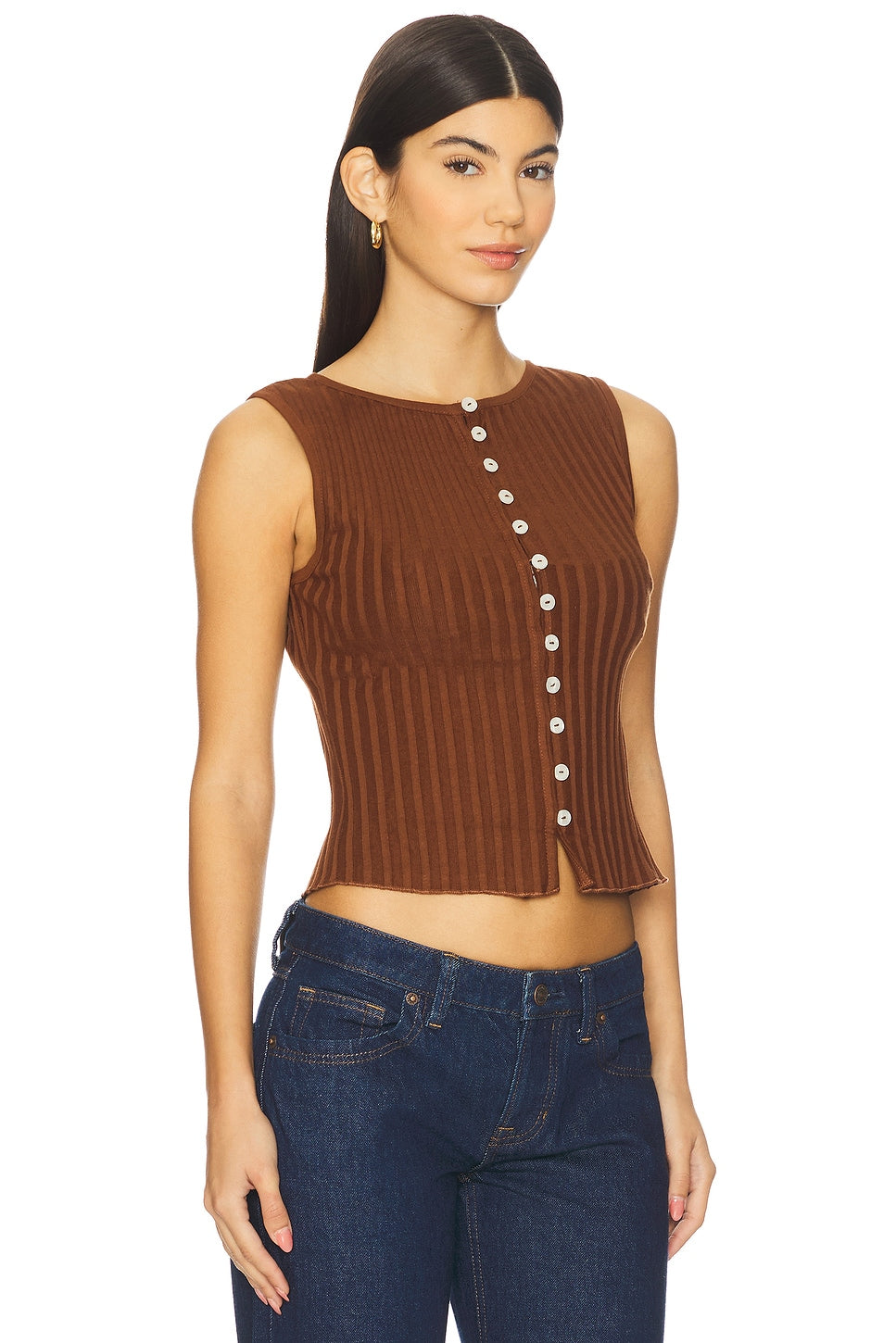 Woman wearing a brown ribbed tank top with buttons and blue jeans