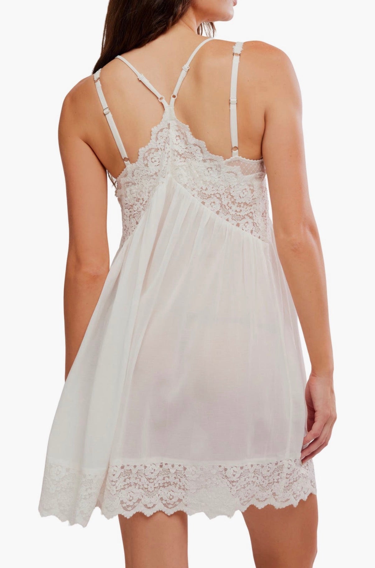 Back view of a woman in an ivory slip dress made of smooth fabric, suitable for layering or sleep, against a plain background.