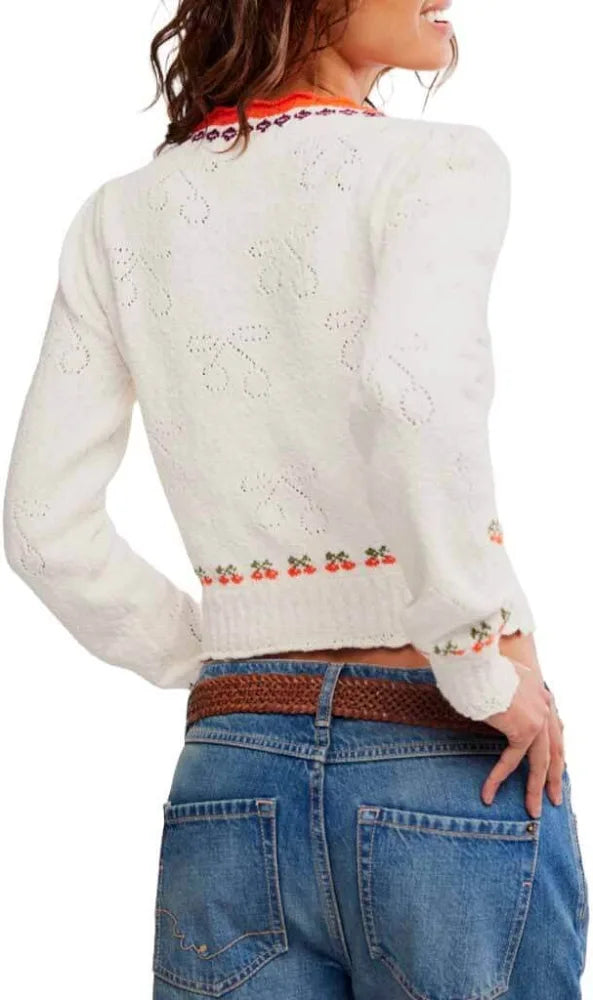 Back view of cropped blue jeans and a cream knit pullover with cherry embroidery. Casual, comfortable attire.