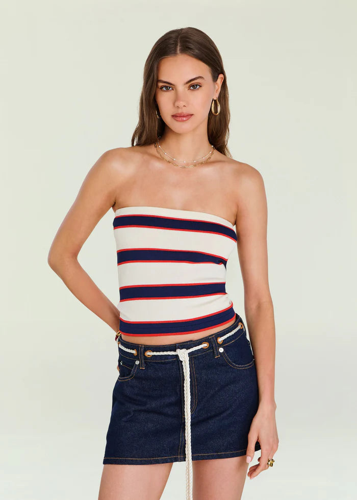 Model in an eggshell-striped knit top and denim mini skirt with rope belt, posed before a plain background.