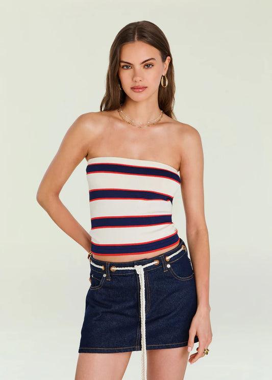 Model in an eggshell-striped knit top and denim mini skirt with rope belt, posed before a plain background.
