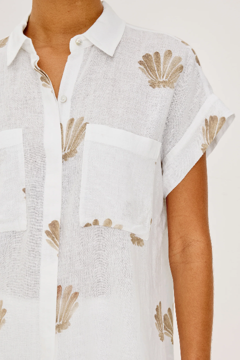 Tan cotton shirt with seashell print and two chest pockets, suitable for casual or warm-weather wear.