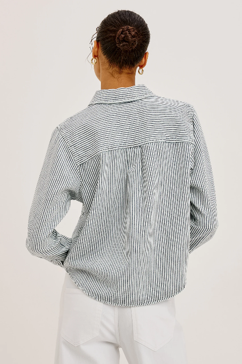 Back view of a striped button-up shirt and white pants, cotton fabric, shown against a plain background.