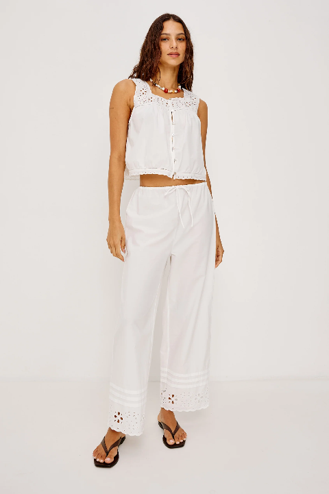 Sleeveless white top with straight-leg, white cotton poplin pants featuring lace details; suitable for casual wear.