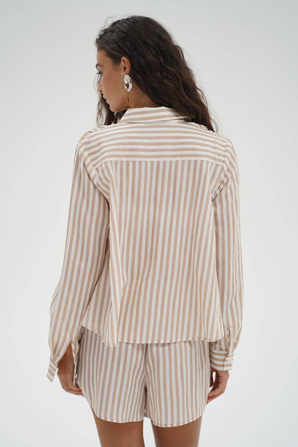 Woman wearing a beige and white striped shirt