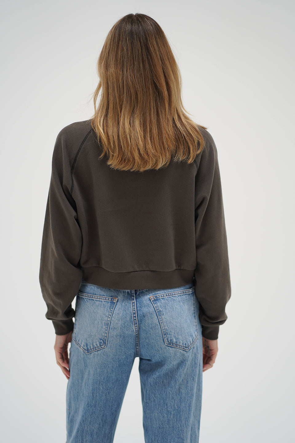 Woman wearing a brown cropped sweater 