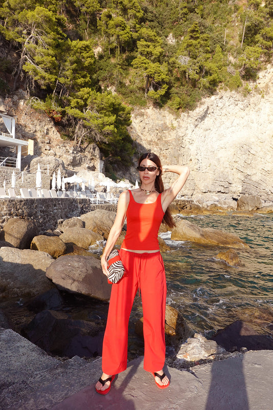 A woman wearing a bright red sleeveless top