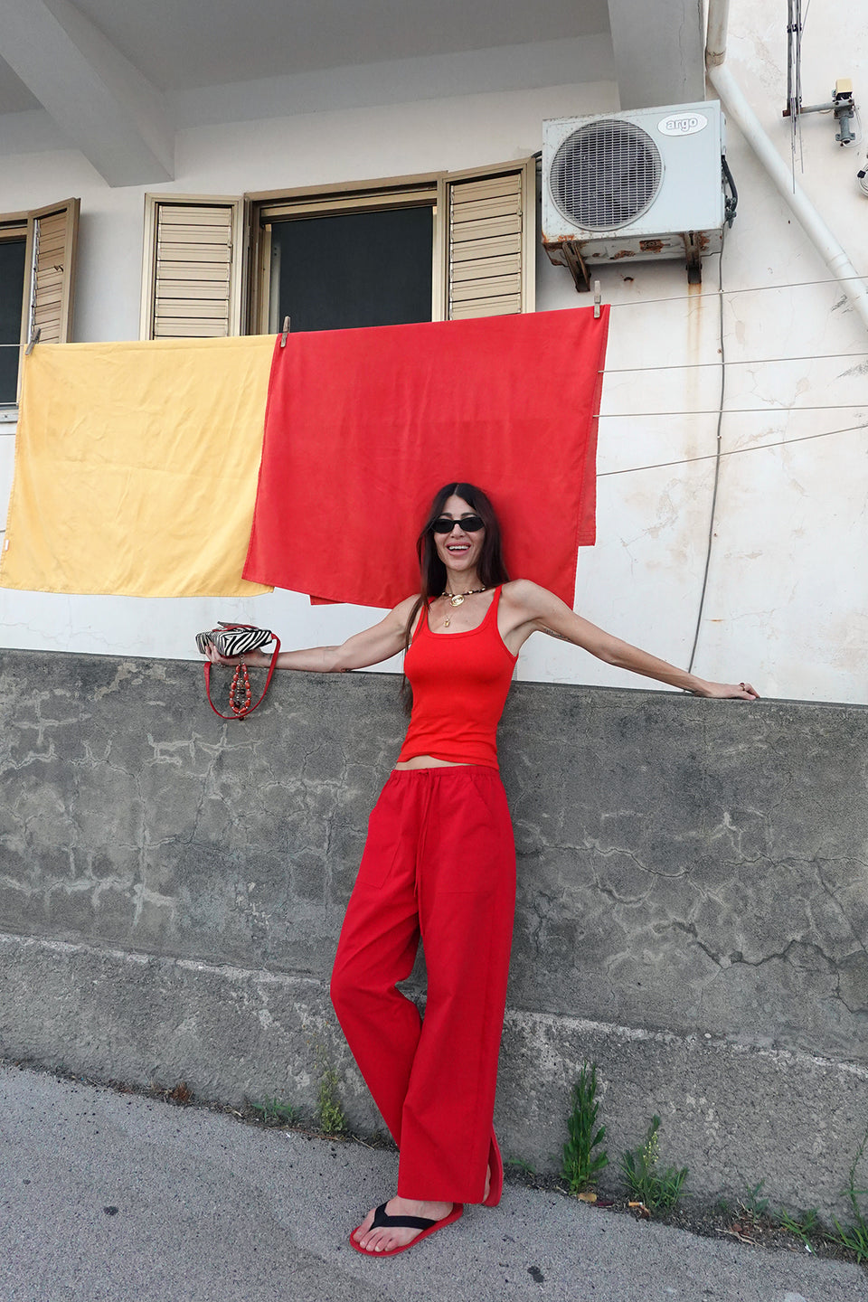 A woman wearing bright red wide-leg drawstring pants and a matching red top