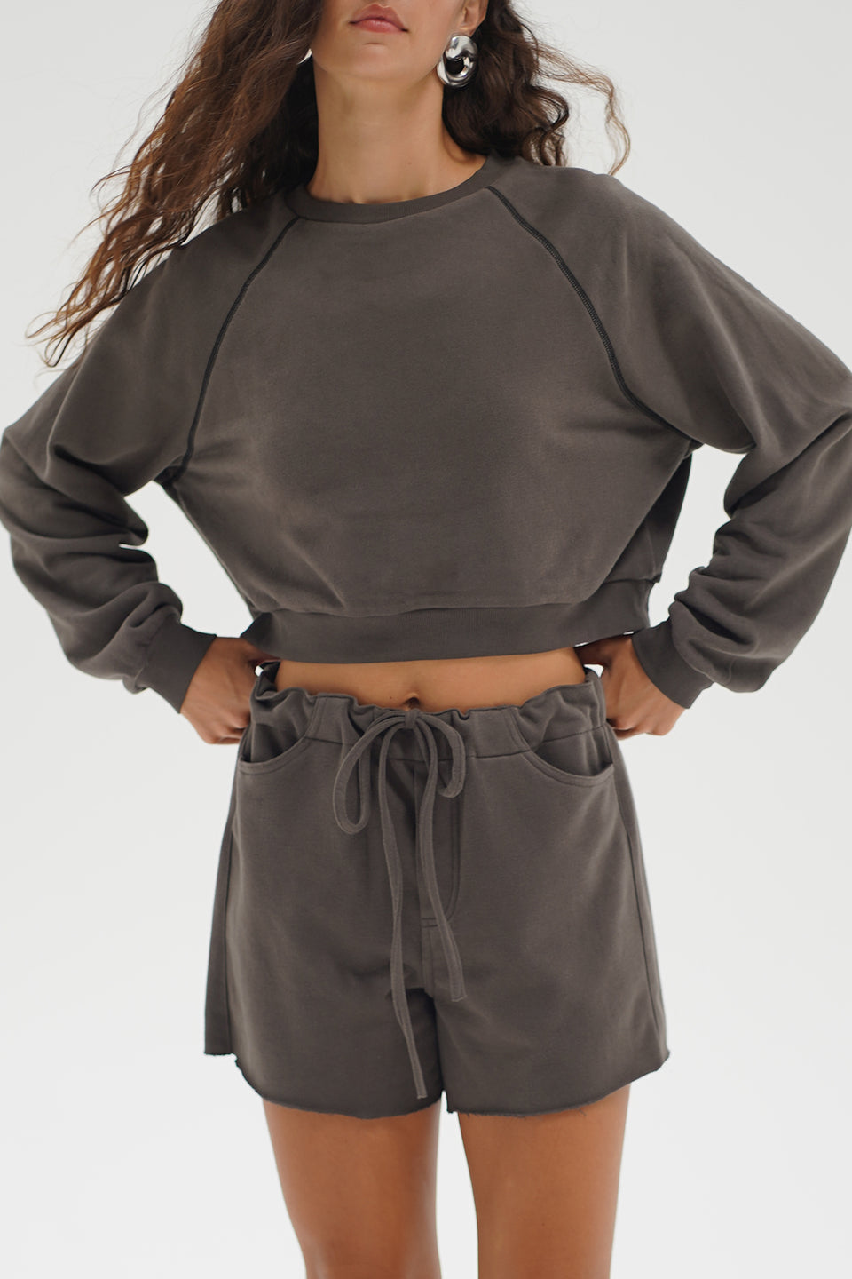 Woman wearing a gray sweatshirt and shorts set 