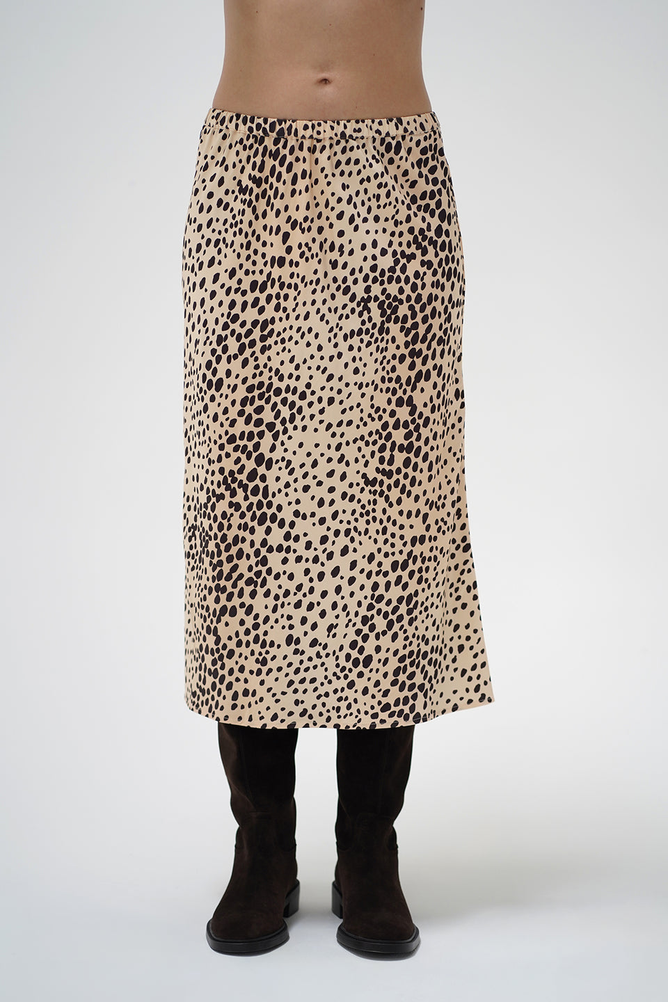 A model wearing a mid-length leopard print skirt