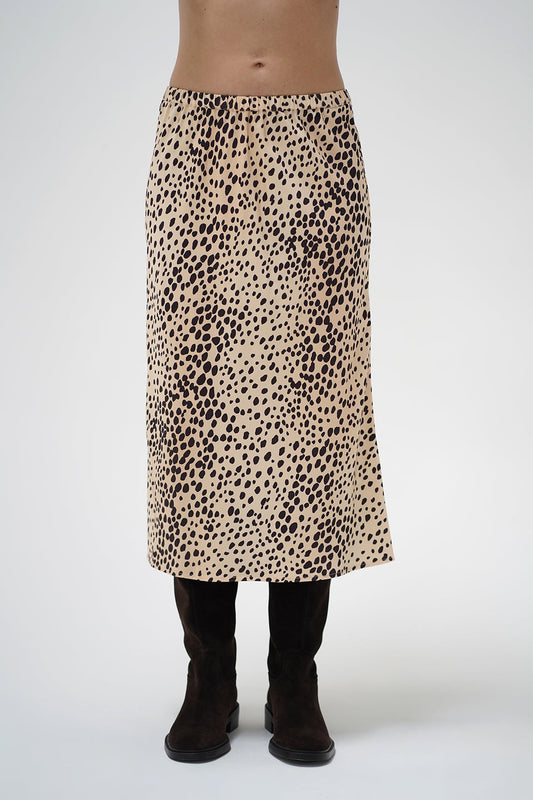 A model wearing a mid-length leopard print skirt