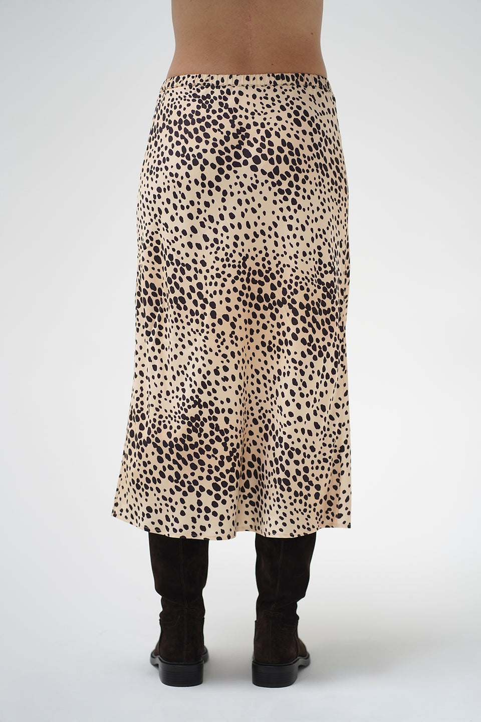 A model wearing a mid-length leopard print skirt