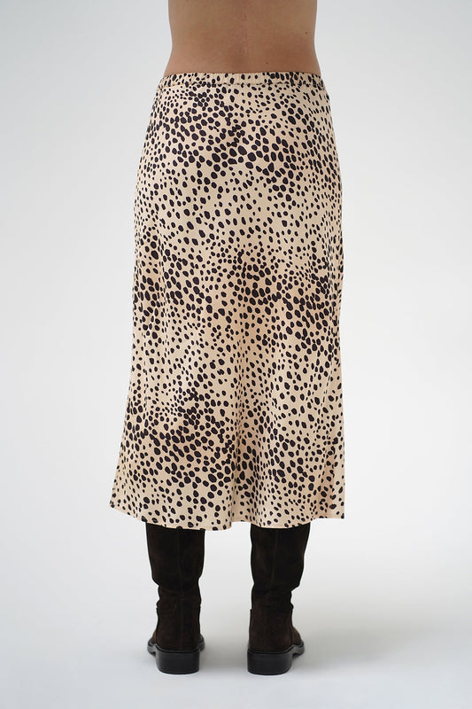 A model wearing a mid-length leopard print skirt