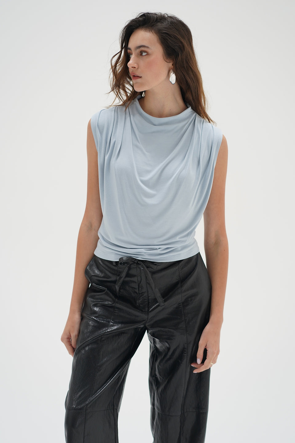 Woman in a light blue drape neck sleeveless top