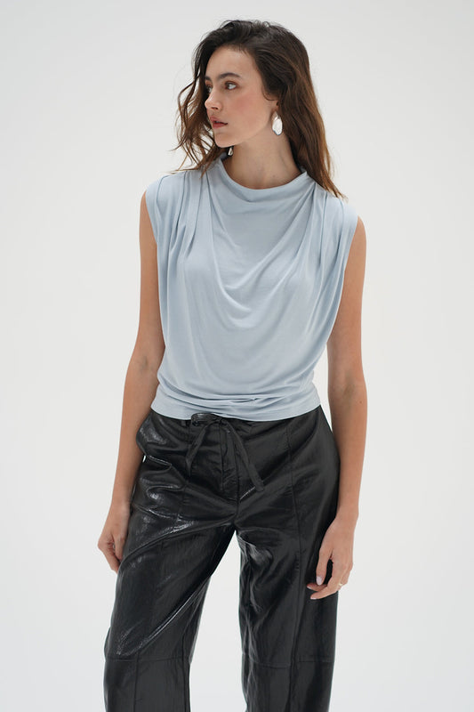 Woman in a light blue drape neck sleeveless top