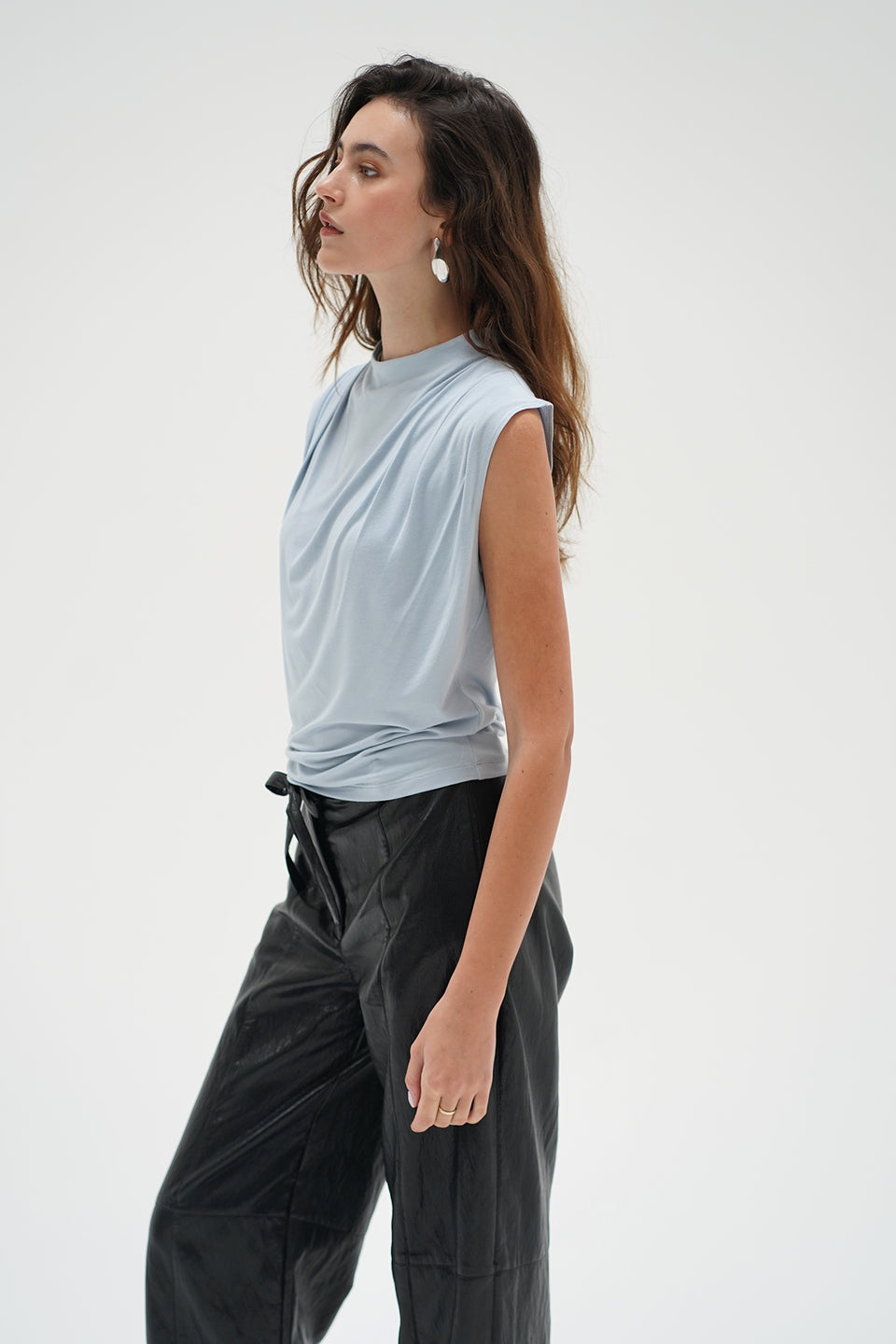 Woman in a light blue drape neck sleeveless top