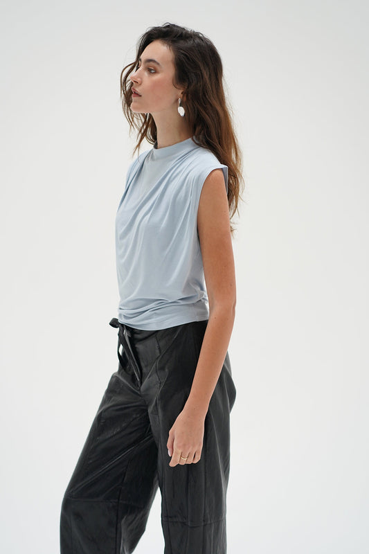 Woman in a light blue drape neck sleeveless top