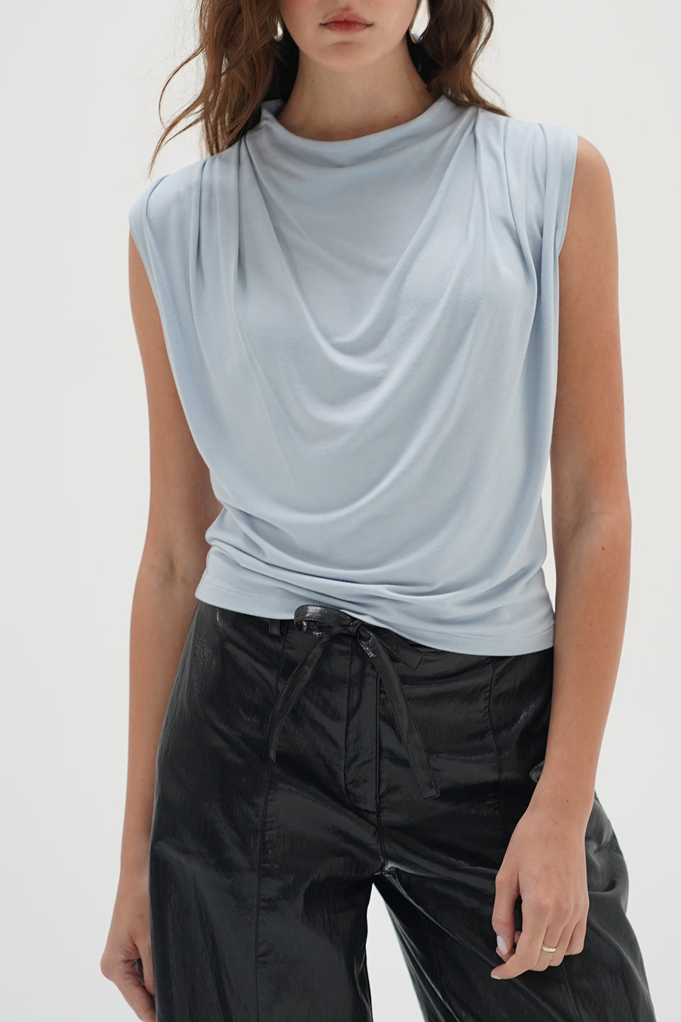 Woman in a light blue drape neck sleeveless top