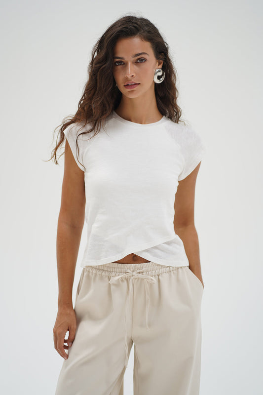 Woman wearing a white top with crisscross bottom