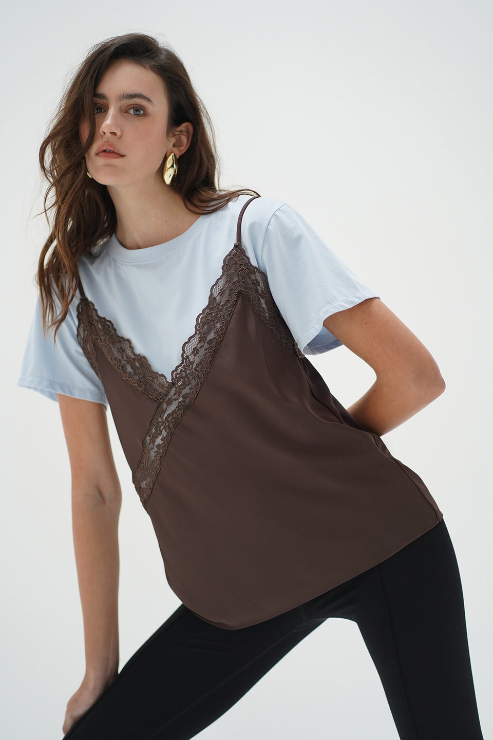 Woman wears a cacao and blue cami layer tee with black pants; outfit suitable for casual or layered looks.