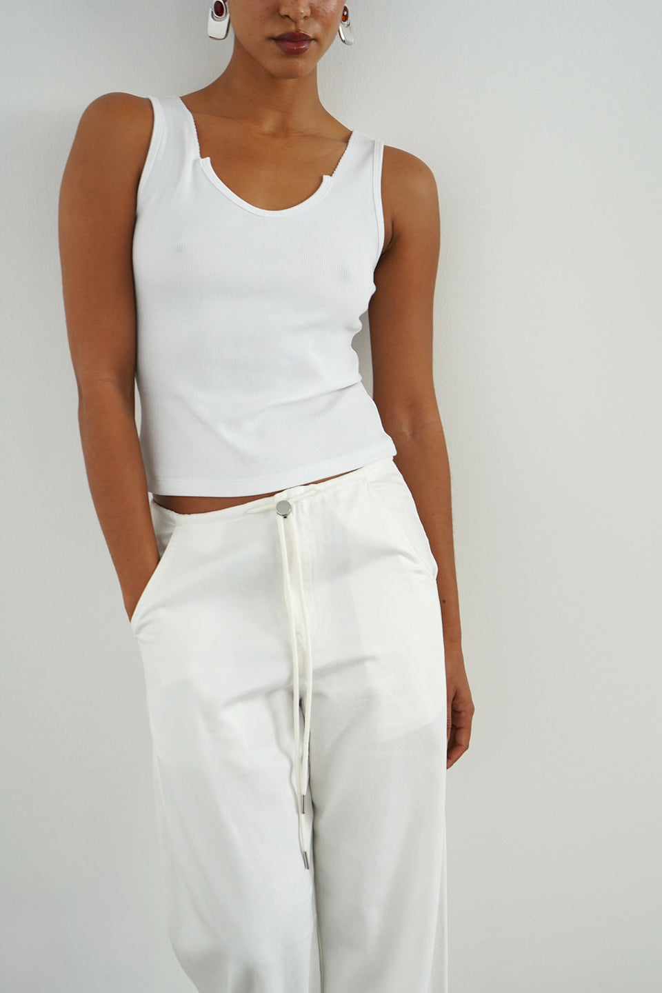 Woman wearing a white ribbed tank top 