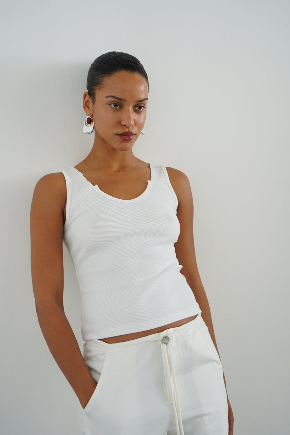 Woman wearing a white ribbed tank top 