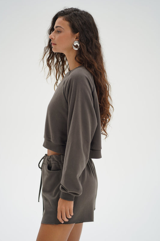 Woman wearing a gray sweatshirt and shorts set