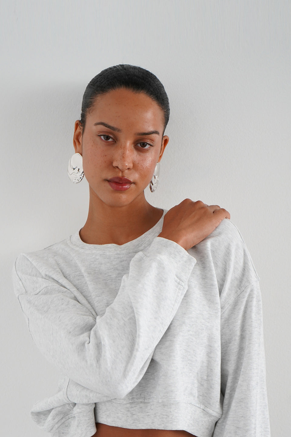 Woman wearing a grey cropped sweatshirt 