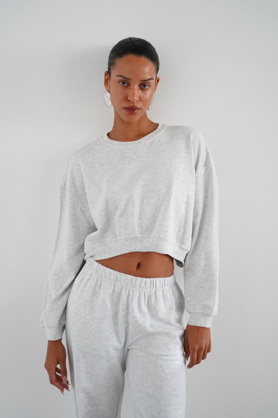 Woman wearing a grey cropped sweatshirt 
