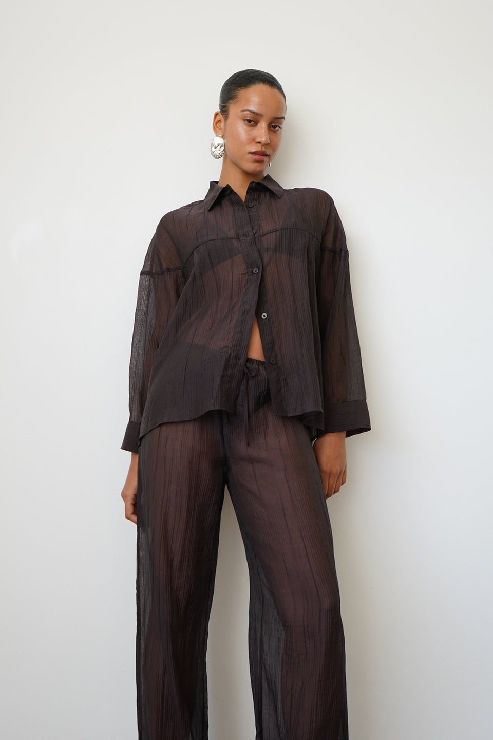 Woman wearing a sheer brown button up