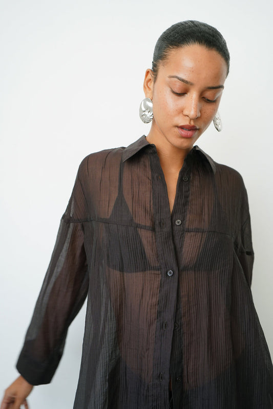 Woman wearing a sheer brown button up