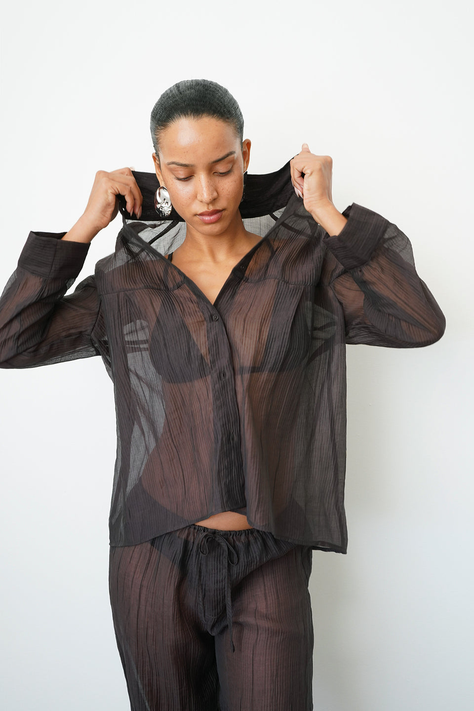 Woman wearing a sheer brown button up