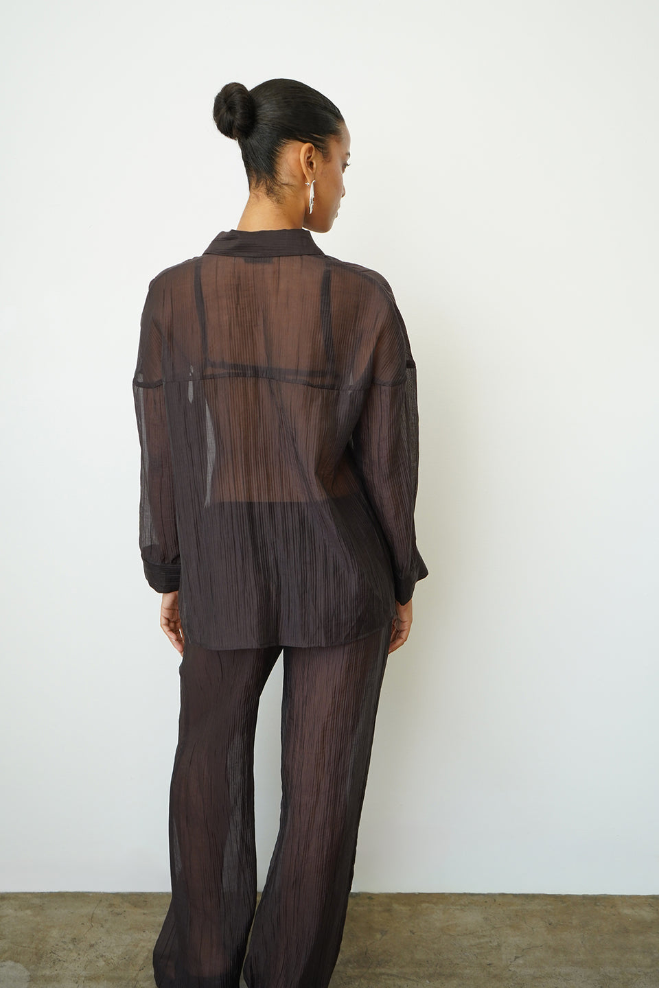 Woman wearing a sheer brown button up
