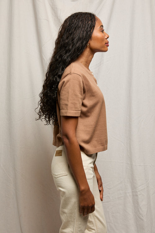 Woman in profile wearing a mocha-colored cardigan, lightweight knit, standing against a neutral background.