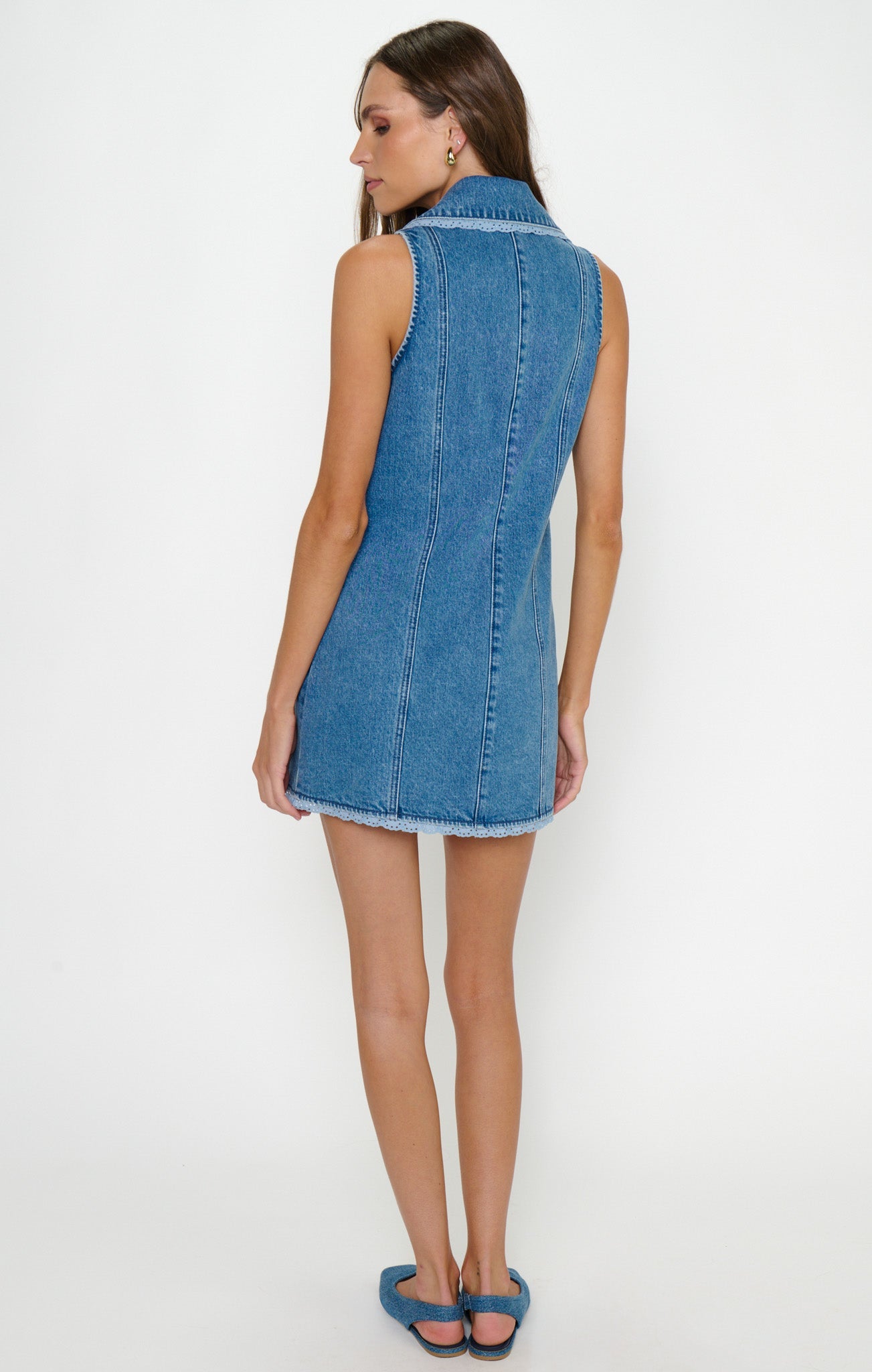 Back view of a woman in a blue sleeveless dress, likely lightweight fabric, suitable for formal or semi-formal occasions.