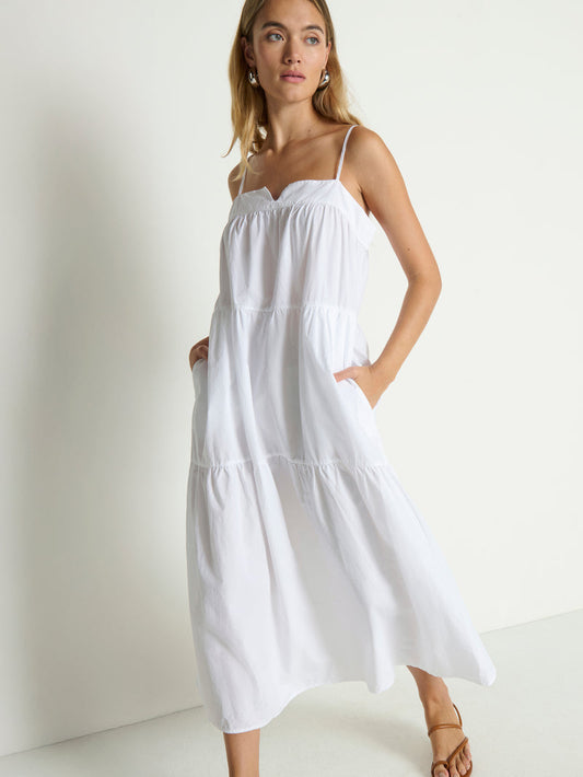 White midi dress with thin straps, likely cotton, suitable for casual wear. Shown on model against a plain white background.