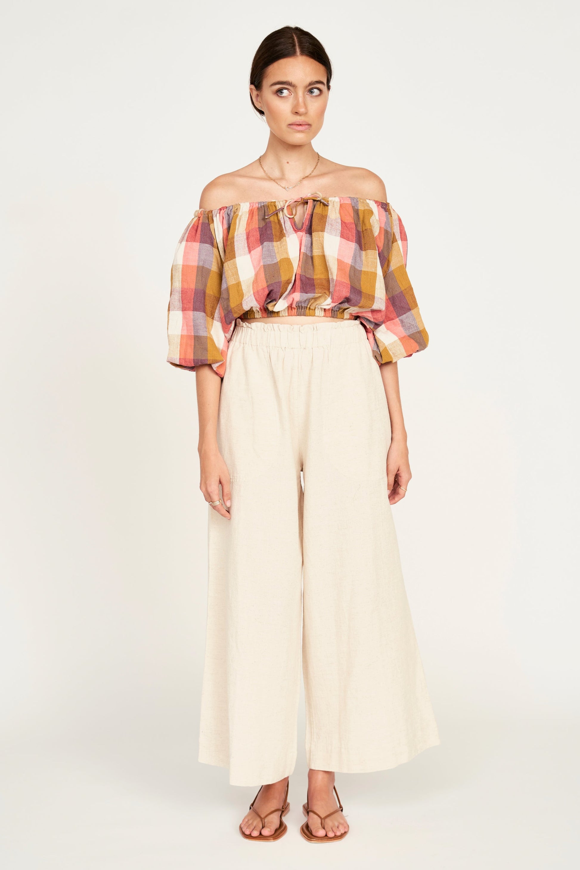 A woman modeling wide-leg cream pants 