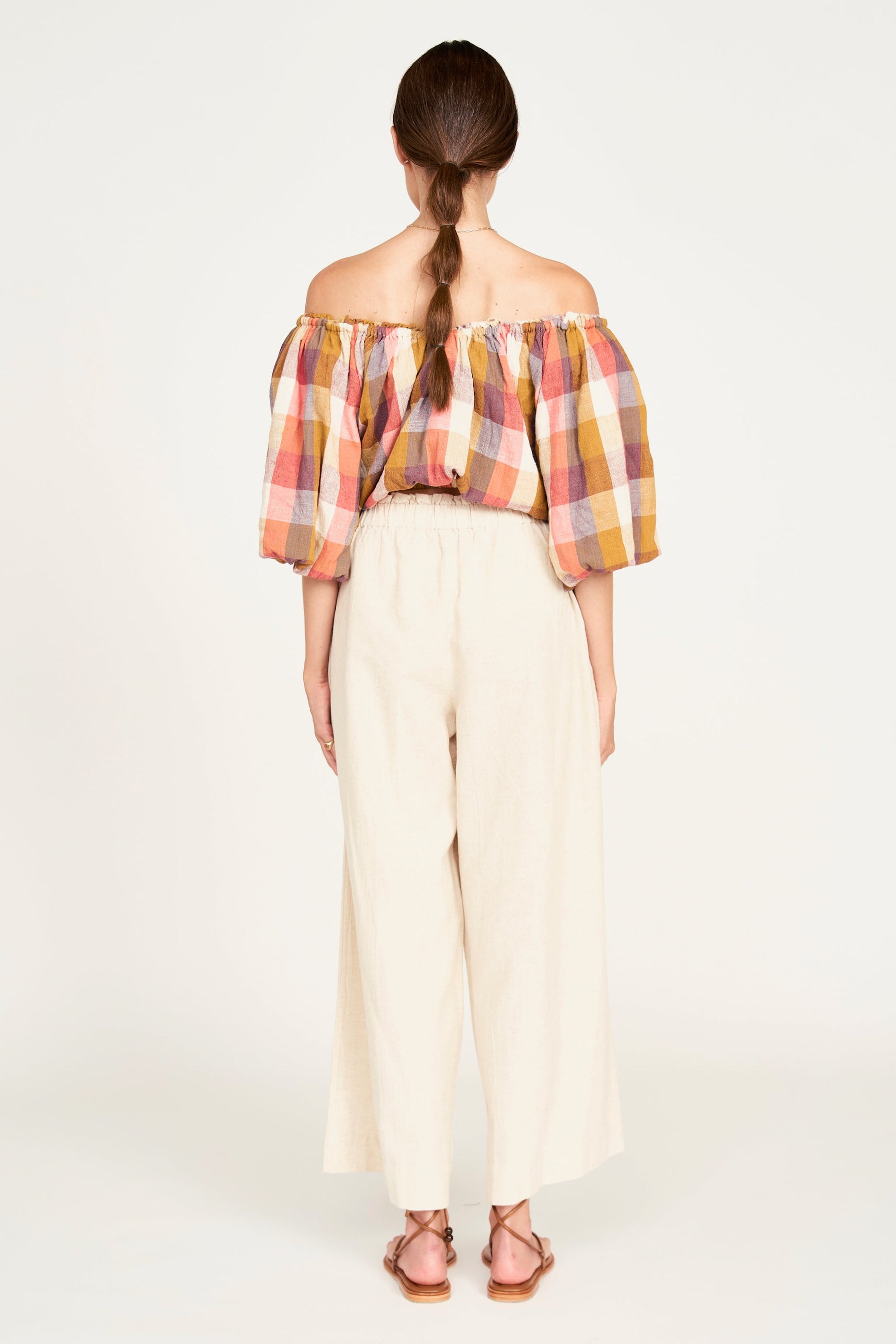 A woman modeling wide-leg cream pants
