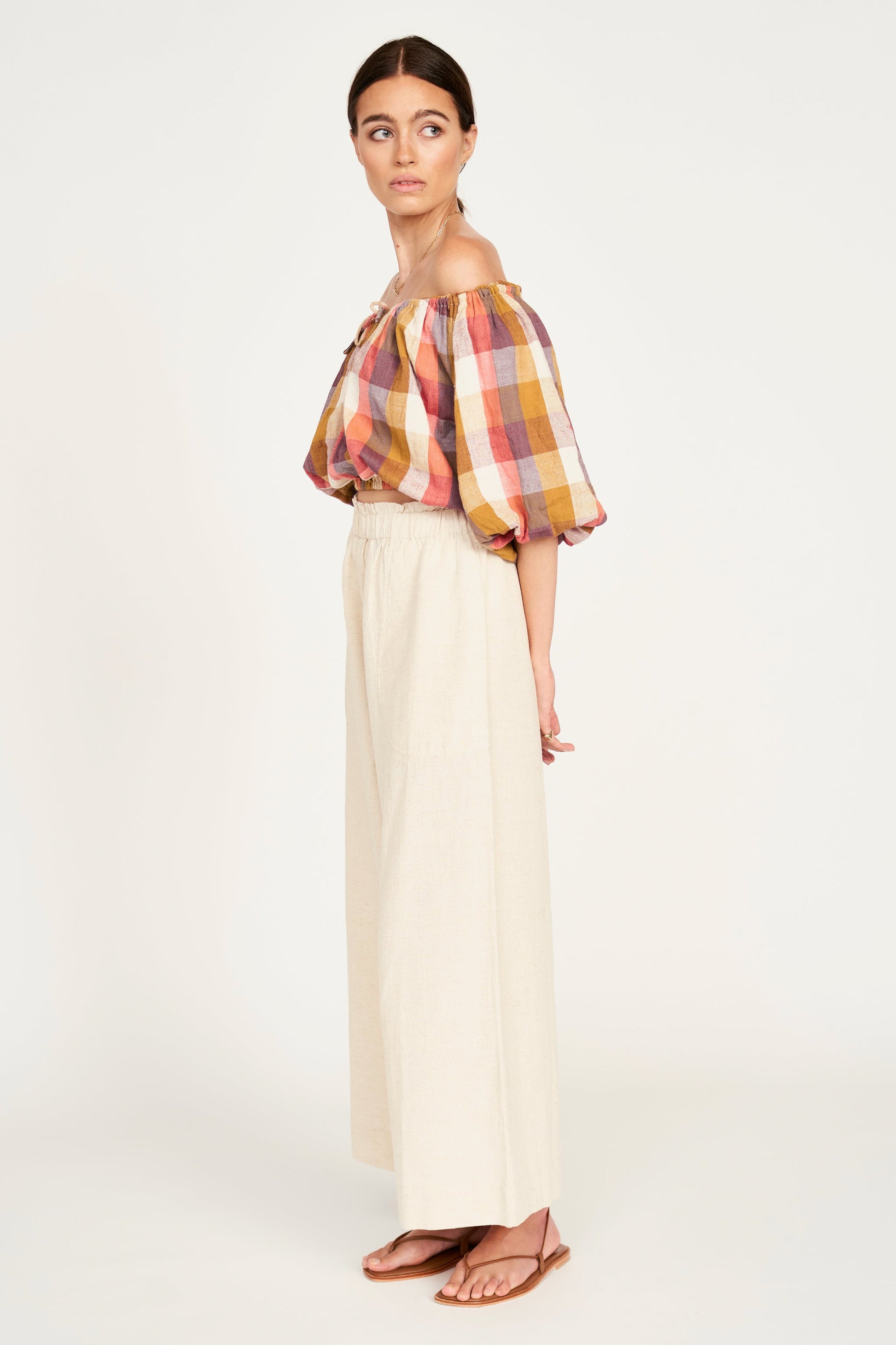 A woman modeling wide-leg cream pants 