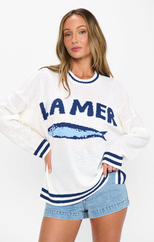 Woman in a white and blue graphic sweater